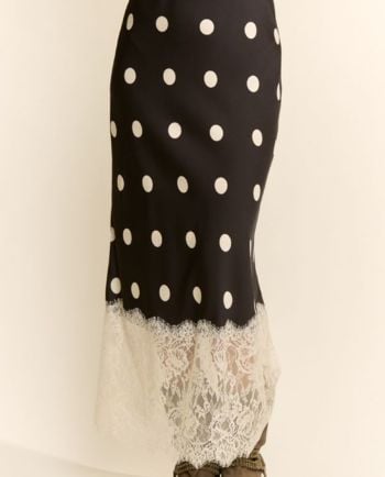Black midi skirt with white polka dots and a delicate ivory lace hem, shown paired with western-style boots.