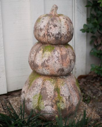 three stacked faux concrete pumpkins