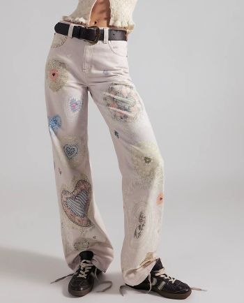 Cream wide-leg jeans with vintage-inspired lace heart patchwork and black lace-up sneakers.