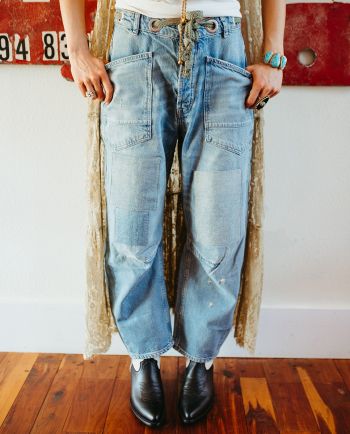 Light wash patchwork jeans with oversized pockets, distressed details, and a rope drawstring waist.