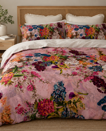 Colorful floral duvet set with pink background on a rattan bed in a cozy neutral bedroom.
